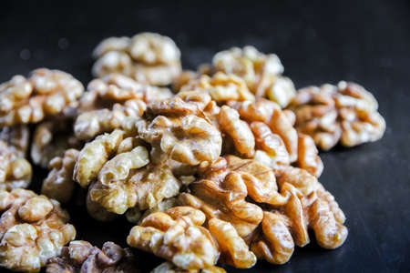 Walnut kernels on a black wooden table. Closeup view