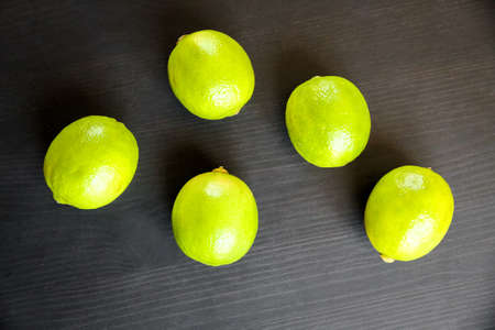 Group of fresh organic limes on a black table backgroundの写真素材
