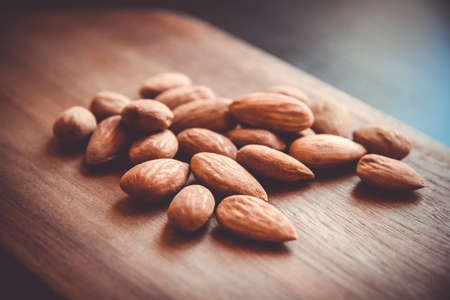 Fresh organic almonds on a wooden cutting boardの写真素材