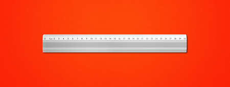 Steel metallic ruler isolated on red backgroundの写真素材