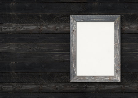 Old rustic wooden picture frame hanging on a black wood wall. Horizontal banner. Blank mockup templateの写真素材