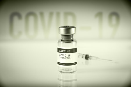 Covid-19 vaccine bottle and syringe on a black and white laboratory backgroundの写真素材