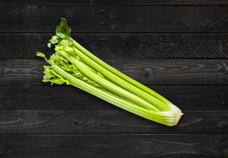 Celery branch bunch on black wood table backgroundの写真素材