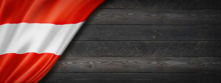 Austria flag on black wood wall. Horizontal panoramic banner.の写真素材