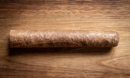 Brown cuban cigar on old wooden background