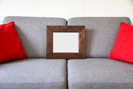 Blank picture frame on a sofa. Minimalist interior backgroundの写真素材