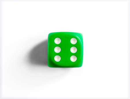 Number 6 on green dice. White background. Top view
