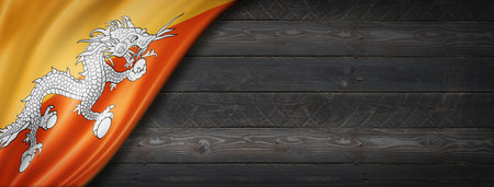 Bhutan flag on black wood wall. Horizontal panoramic bannerの写真素材