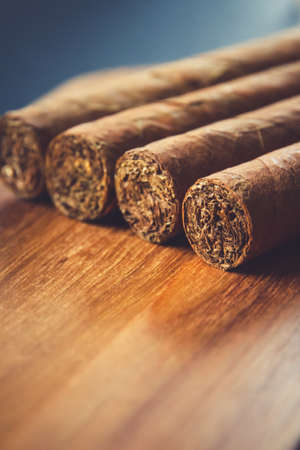 Group of brown cuban cigars on old wooden backgroundの写真素材