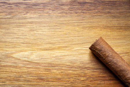 Brown cuban cigar on old wooden backgroundの写真素材