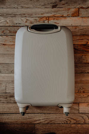 Vintage travel suitcase isolated on old wooden backgroundの写真素材