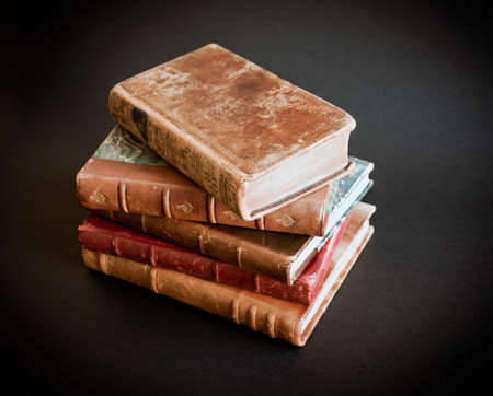 Stack of old books isolated on black backgroundの写真素材