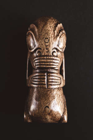 traditional wooden Polynesian tiki from Marquesas Islands. Isolated on a dark backgroundの写真素材