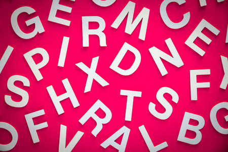 Mixed solid letters pile top view photo. Education concept on pink background.の写真素材