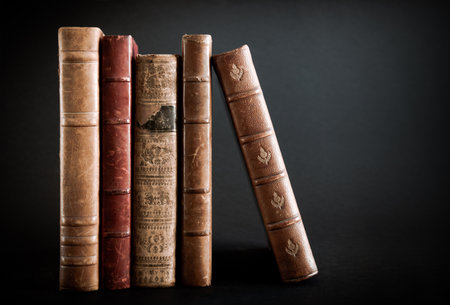 Row of old books isolated on black backgroundの写真素材