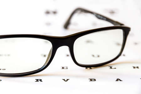 Glasses on eye chart. Optical device backgroundの写真素材