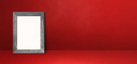 Wooden picture frame leaning on a red wall. Blank mockup template. Horizontal bannerの写真素材
