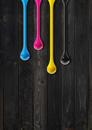 3D cmyk ink drops isolated on black wooden background. Illustrationの写真素材