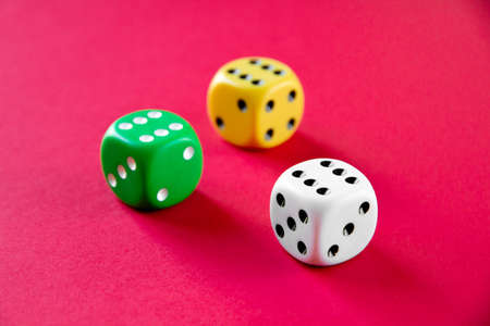 Three colorful dices isolated on pink backgroundの写真素材