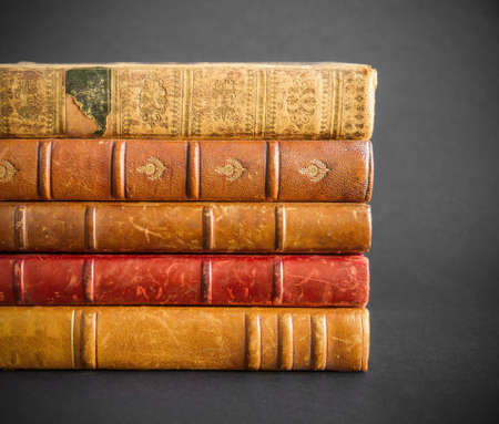 Stack of old books isolated on dark backgroundの写真素材
