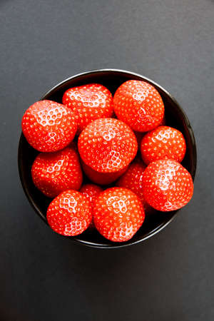 Strawberries in a bowl. Black background. Studio shootingの写真素材