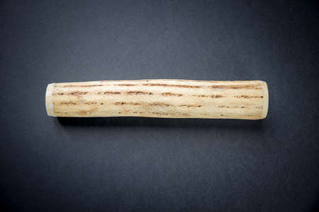 Traditional rain stick made of cactus wood isolated on black background