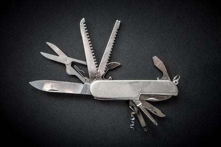 Metallic swiss knife isolated on black backgroundの写真素材