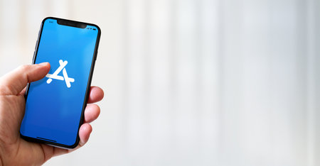 Paris - France - March 15, 2022 : Hand holding iphone smartphone with App Store logo. Horizontal bannerのeditorial素材