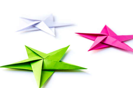 Pink, green and white paper star origami isolated on a blank background.