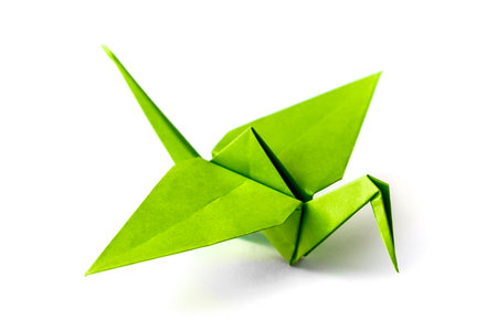 Green paper crane origami isolated on a blank white background.の写真素材