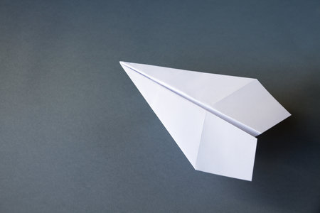 White paper plane origami isolated on a blank grey backgroundの写真素材