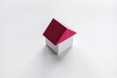 White and red paper house origami isolated on a blank background.の写真素材