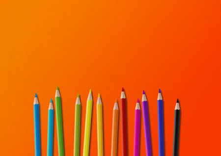 Wooden colored pencil set isolated on orange. Horizontal background.の写真素材
