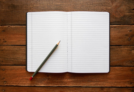 Open notebook and pencil on a rustic vintage wooden boardの写真素材