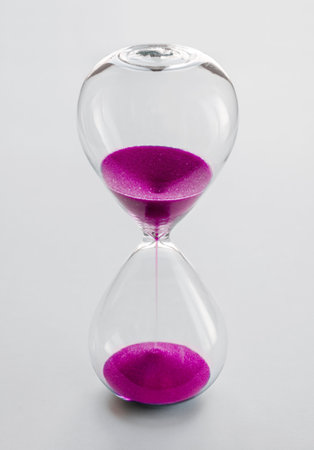 Hourglass containing pink sand isolated on white background.の写真素材