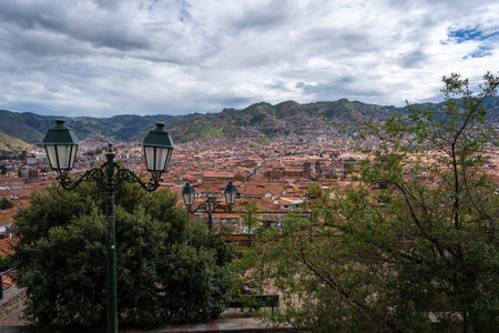 The city of Cusco, Peru, unfolds with terracotta rooftops, colonial architecture, and historic churches, nestled in a valley surrounded by the towering Andes Mountainsの写真素材