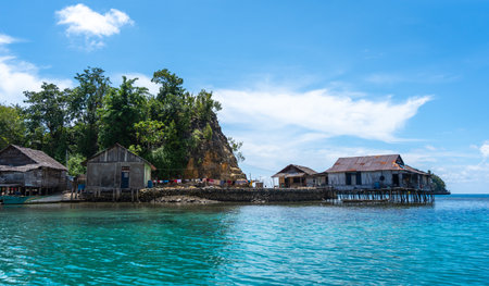 Traditional Bajo houses on wooden stilts above turquoise water in a remote coastal village of the...