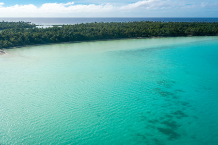 Stunning aerial view of the motus and lagoon surrounding Maupiti Island in French Polynesia, featuring turquoise waters and lush greeneryの写真素材