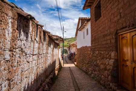 A quiet street in Chinchero, Peru, lined with white adobe houses and stone walls. The cobblestone pathway reflects the townâs colonial and Andean heritageの写真素材