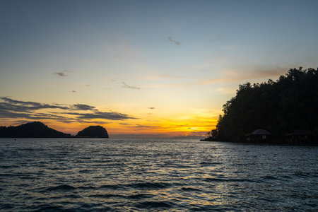 Golden sunset over Bolilanga Island in the Togian archipelago, Sulawesi, Indonesia, with glowing...