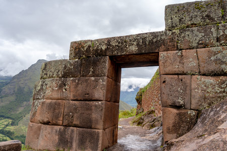The Inca archaeological site of Pisac sits atop a lush green valley surrounded by misty Andean peaks. Stone terraces and ancient walls blend with the natural landscape, offering a glimpse into Peruâs rich history and breathtaking sceneryの写真素材