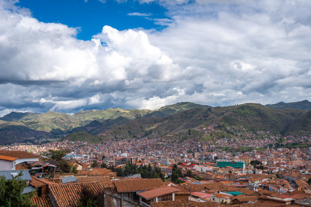 The city of Cusco, Peru, unfolds with terracotta rooftops, colonial architecture, and historic churches, nestled in a valley surrounded by the towering Andes Mountainsの写真素材