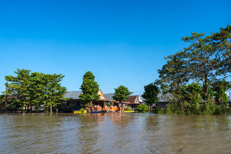 Houses on Lake Tempe in Sulawesi, Indonesia reflect on calm waters, surrounded by lush vegetation and traditional lakeside village lifeの写真素材