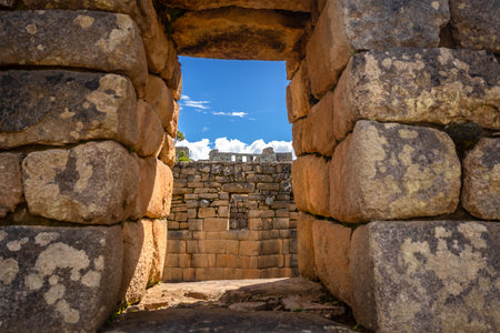 Lush green terraces and precisely carved stone walls within Machu Picchu under the bright Andean skyの写真素材