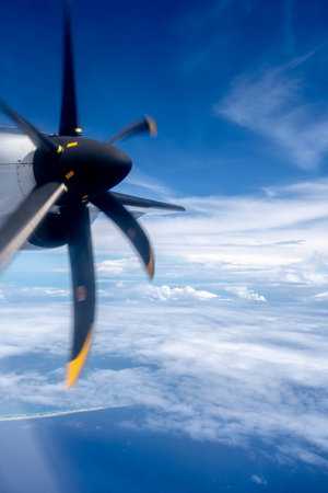 View from an airplane flying over the Pacific Ocean, with a spinning propeller in the foreground....