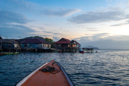 Wooden fishermen houses of Pulau Papan glow under the soft sunset light, surrounded by calm sea...