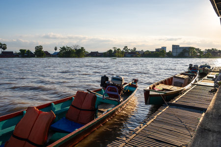 A traditional Bujis fishing boat rests on the water near floating houses on Lake Tempe in Sulawesi, Indonesiaの写真素材