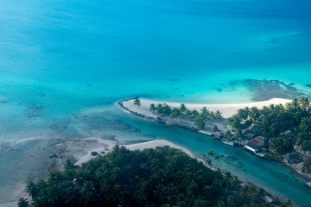 A breathtaking aerial view of a motu in Tikehau Atoll, French Polynesia. The turquoise waters contrast beautifully with the sandy islets and lush green vegetationの写真素材