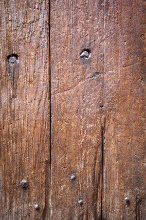 A detailed close-up of a weathered wooden door, revealing its intricate textureの写真素材