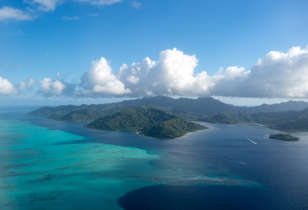 Tahaa island in French Polynesia, seen from above, reveals a turquoise lagoon, coral reef, and lush...